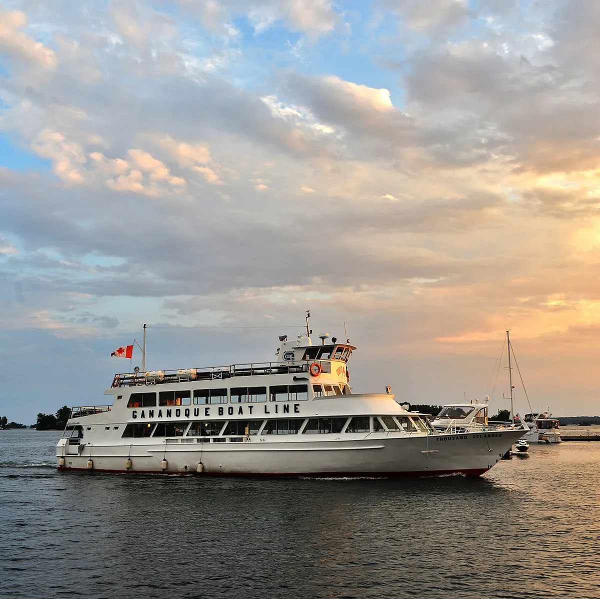 Passenger boat on a 3-hour Gananoque boat tour cruising past ocean freighters and islands on the St. Lawrence Seaway in the 1000 Islands